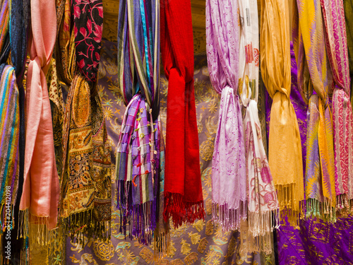 Row of colorful silk scarvers hanging on market stall, India   © SimoneGilioli