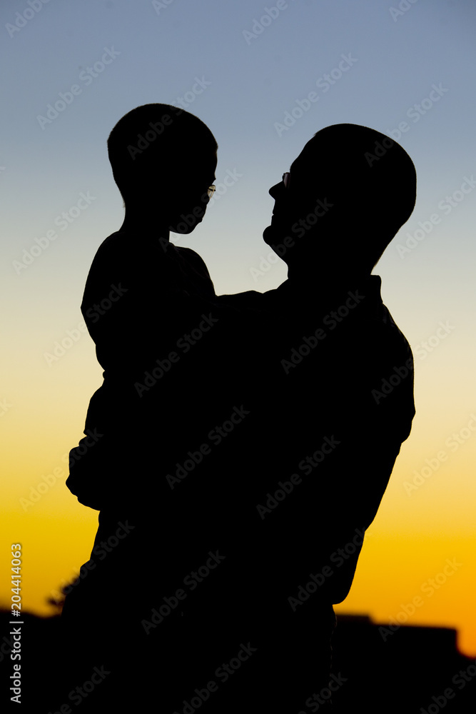 Silhouette of Father Holding Son at Sunset