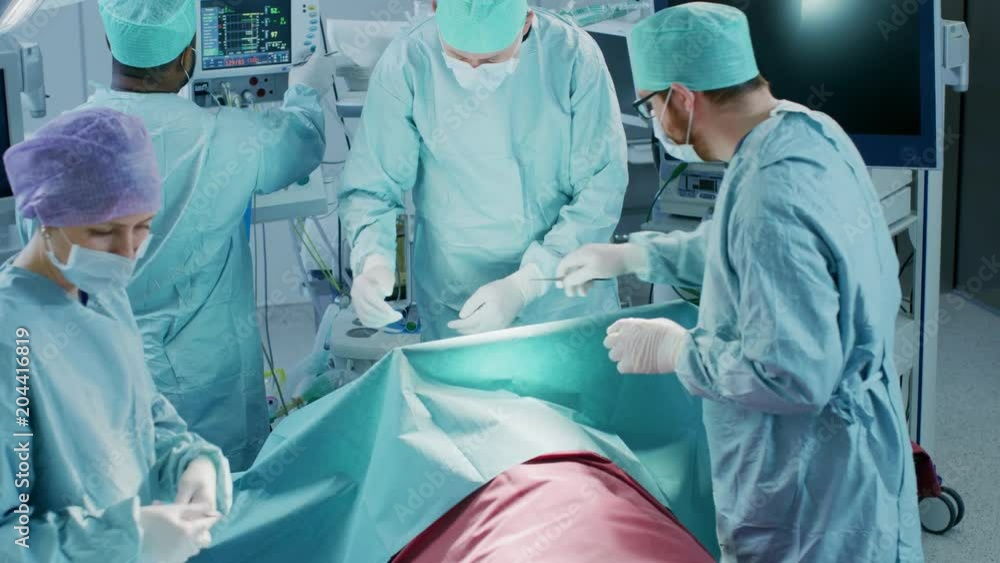 Diverse Team of Professional surgeon, Assistants and Nurses Performing Invasive Surgery on a Patient in the Hospital Operating Room. Surgeons Talk and Use Instruments. Diverse Team of Professional surgeon, Assistants and Nurses Performing Invasive Surgery on a Patient in the Hospital Operating Room. Surgeons Talk and Use Instruments.