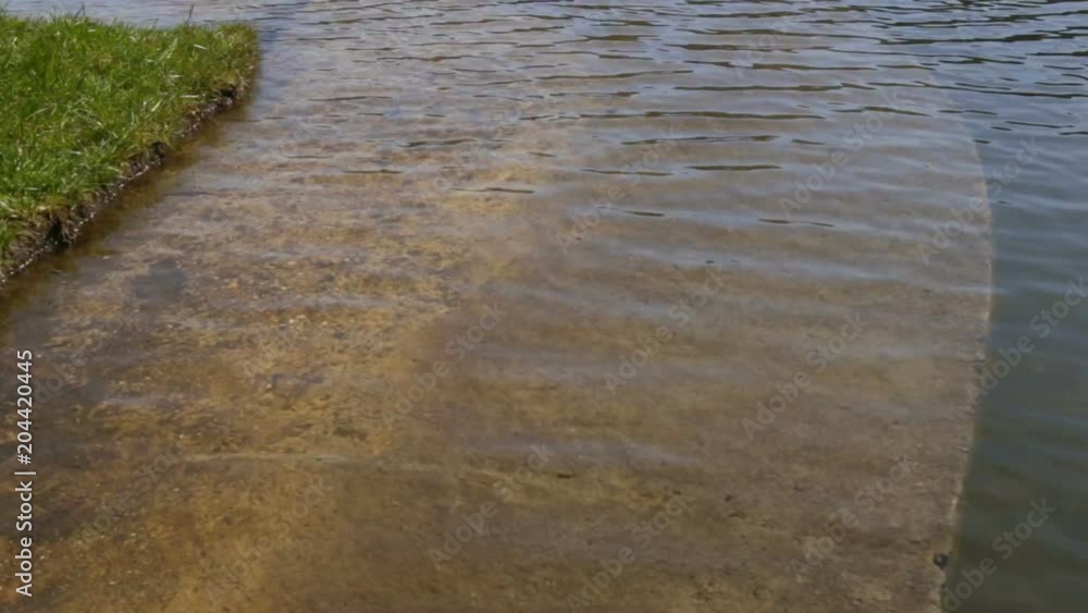 The concrete embankment of the river flooded with water due to spring floods. River out of concrete channel The concrete embankment of the river flooded with water due to spring floods. River out of concrete channel