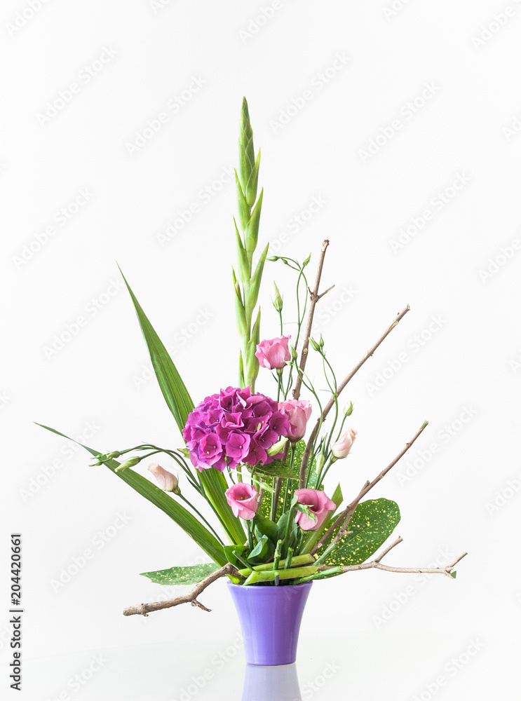 Artistic floral decoration on a table in a ceramic flowerpot isolated on white background. Artistic floral decoration on a table in a ceramic flowerpot isolated on white background.