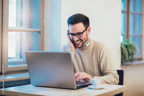 Man in front of laptop computer with headset