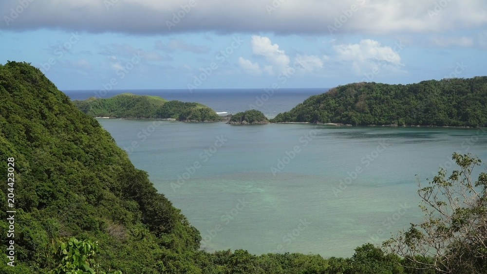Naklejka premium Seascape tropical island, lagoon, beach and hills.. Tropical landscape sky, clouds and mountains rocks with rainforest. Blue lagoon in the ocean. Travel concept.