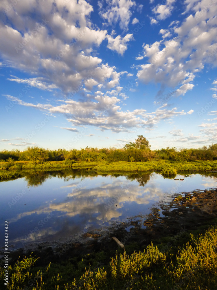 A view of the pampa biome, clouds reflecting on small pond - Uruguaiana, Brazil A view of the pampa biome, clouds reflecting on small pond - Uruguaiana, Brazil