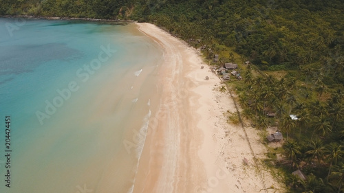 Aerial view of beautiful tropical island with sand beach. Tropical lagoon with turquoise water and yellow sand. Seascape: Ocean and a beautiful beach paradise. Beautiful view of a nice tropical beach