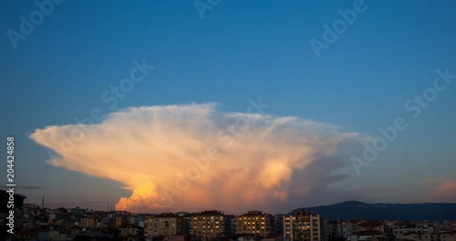 Cumulonimbus Capillatus clouds with some cumulus clouds while getting dark and sun going down. photo