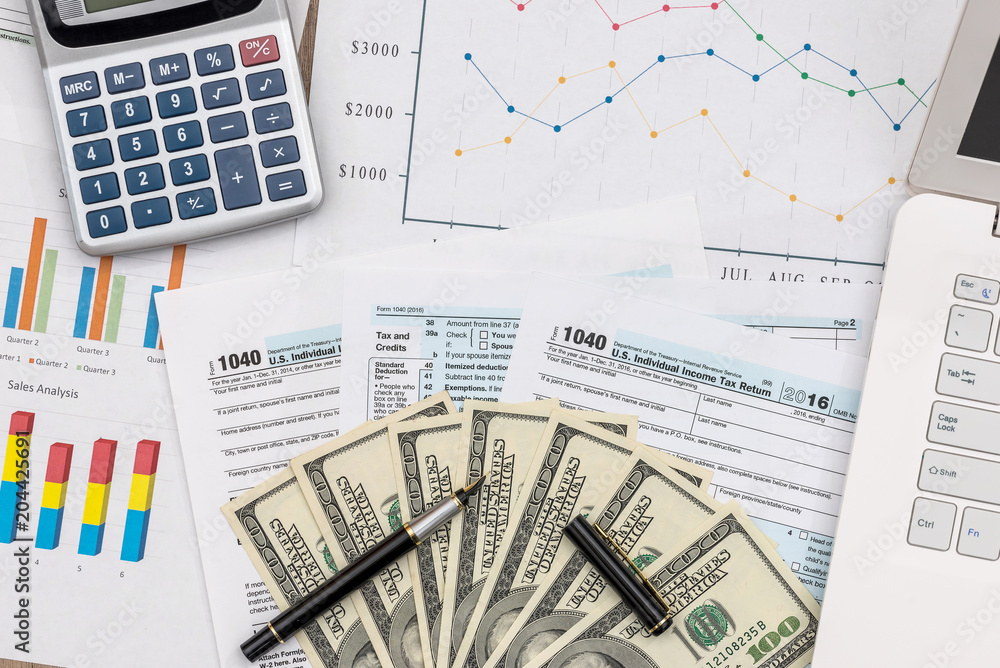 Taxation concept, business graphs with dollar banknotes and laptop Taxation concept, business graphs with dollar banknotes and laptop