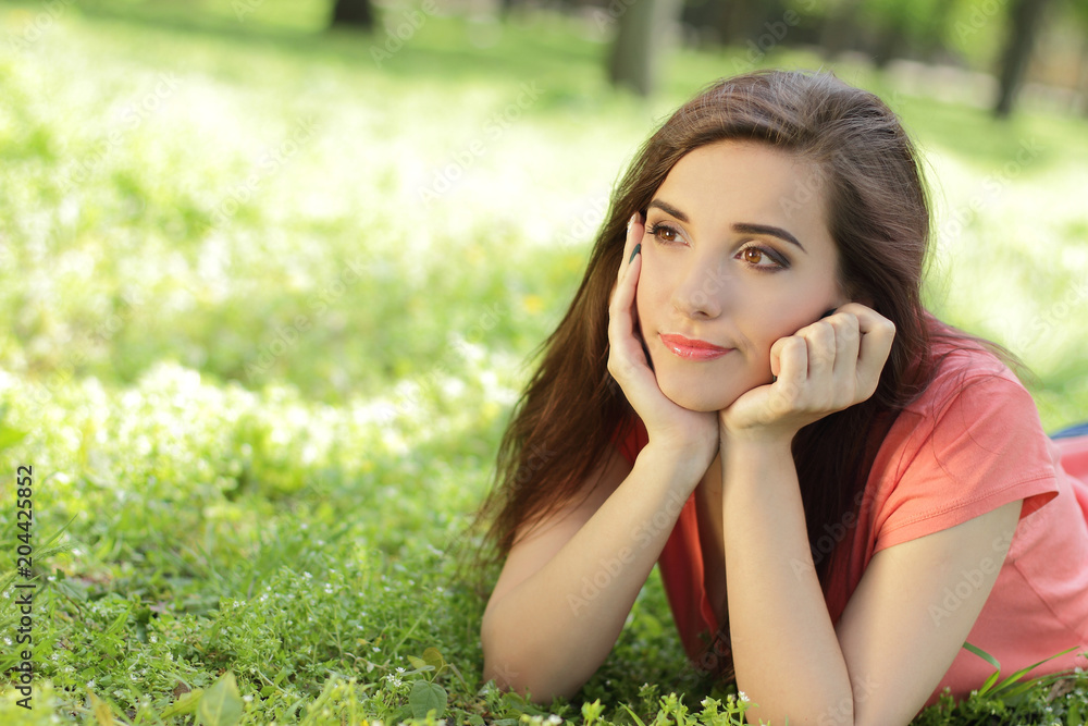 young beautiful girl in the grass, serious look, puzzled young beautiful girl in the grass, serious look, puzzled