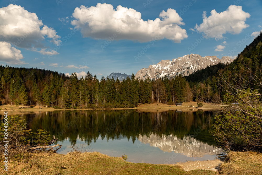 Fototapeta premium Reflections of the Kampenwand at Ferchensee and wood