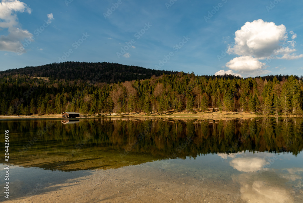 A alone hut in front of a forest with great reflections at Ferchensee