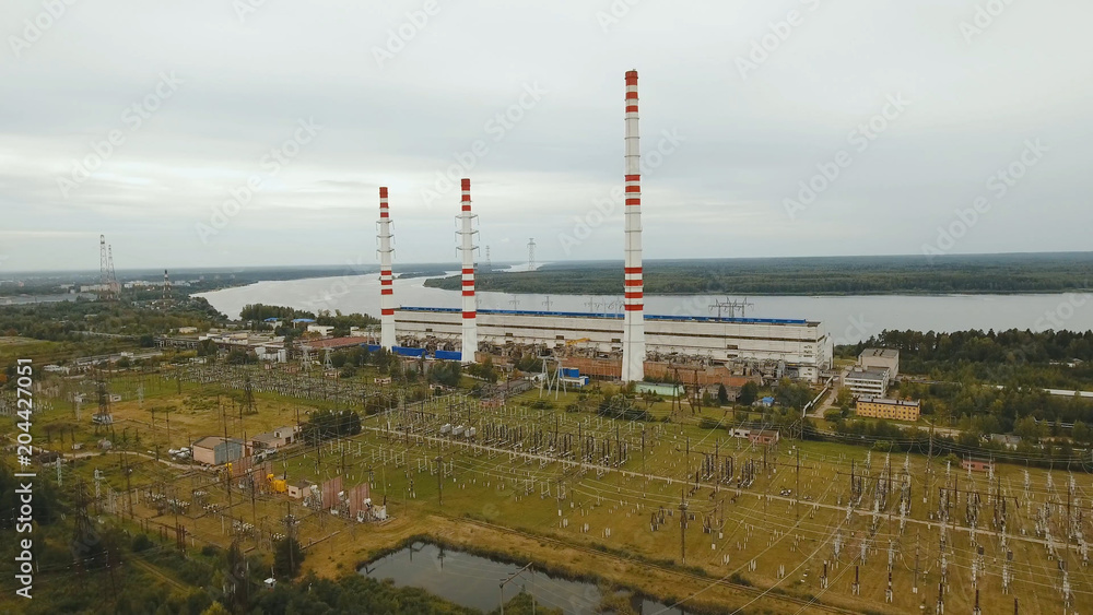 Aerial view Hydroelectric power station, transformation station, cables and wires. High voltage electric power substation. Electrical power transformer in high voltage substation.