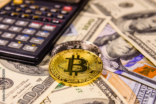 Bitcoins and scientific calculator on the one hundred dollar bills