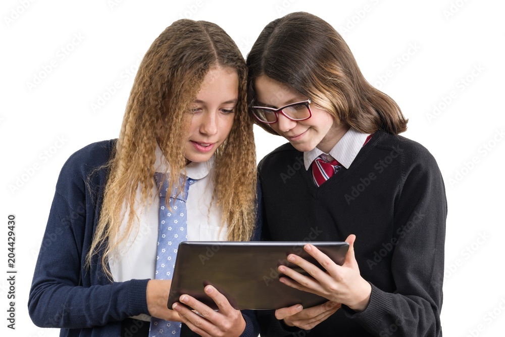 Happy high school friends closeup portrait. Teenage girls in school uniform on white background, with tablet, picture is isolated Happy high school friends closeup portrait. Teenage girls in school uniform on white background, with tablet, picture is isolated