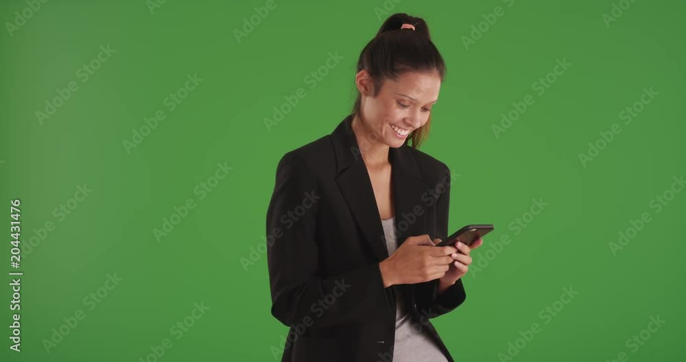 Happy businesswoman reading text messages on smartphone on greenscreen Happy businesswoman reading text messages on smartphone on greenscreen