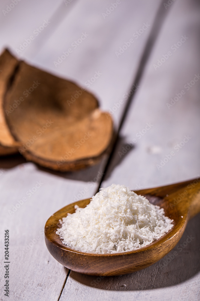 Coconut flakes in a shell on a blue background Coconut flakes in a shell on a blue background