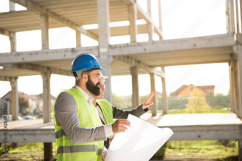 A hipster architect and a beautiful female engineer on a construction site. A hipster architect and a beautiful female engineer on a construction site.