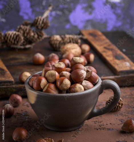 whole hazelnut nutshell in a brown clay cup