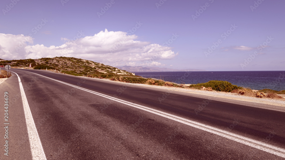 Deserted highway along the sea, travel concept. Vintage toned. Greece, Crete.