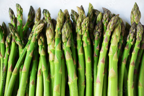 Green fresh asparagus on gray background. Top view. Raw, vegan, vegetarian and clean eating concept.