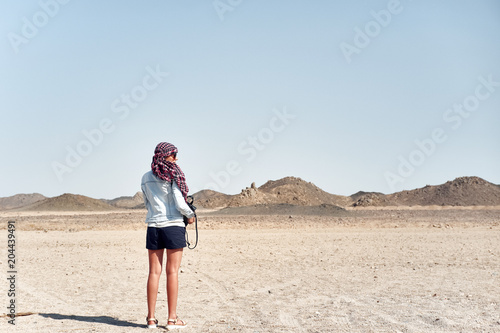 Woman in the desert is standing with her back looking silhouetted