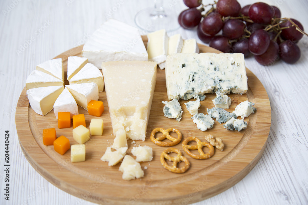 Tasting cheese with wine, grapes and pretzels on wooden background. Food for romantic. Side view.