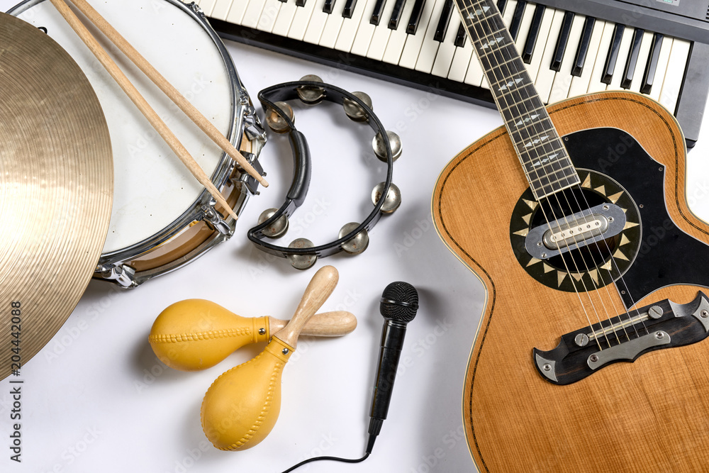 Naklejka premium a group of musical instruments including a guitar, drum, keyboard, tambourine.
