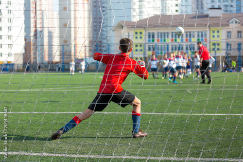 football goalkeeper on the training on the field in the summer. he catches a ball after kicks 