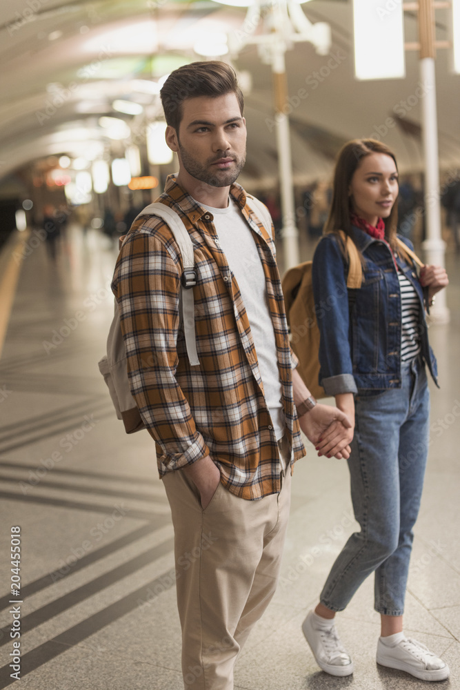stylish couple of tourists at subway station