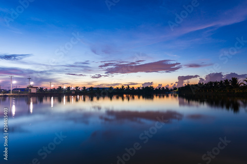 A time traveler at sunrise with a reflection in the lake.