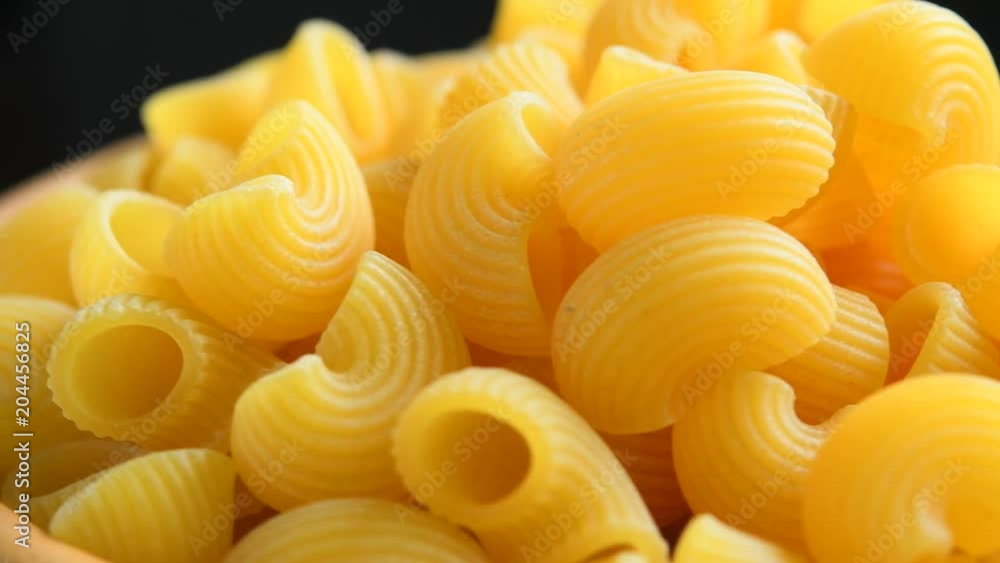 Uncooked macaroni pasta rotating background Uncooked macaroni pasta rotating background