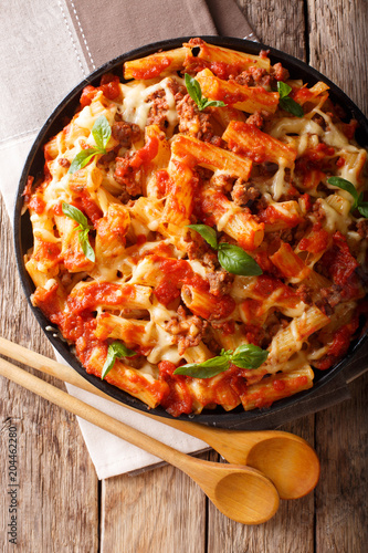 Delicious pasta with ground beef, tomatoes and cheese close-up. Vertical top view