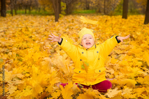 Happy adorable child girl with leaves in autumn park. Fall.The concept of childhood  family and kid