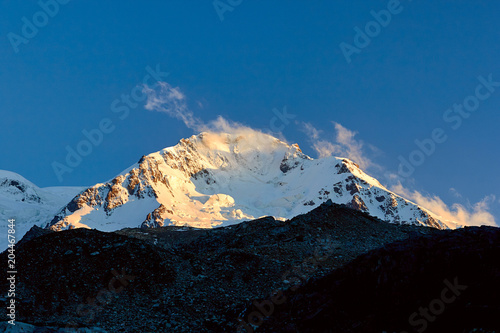 Sunset in mountains. Reflection of red sun on mountain snow peaks  Fann  Pamir Alay  Tajikistan