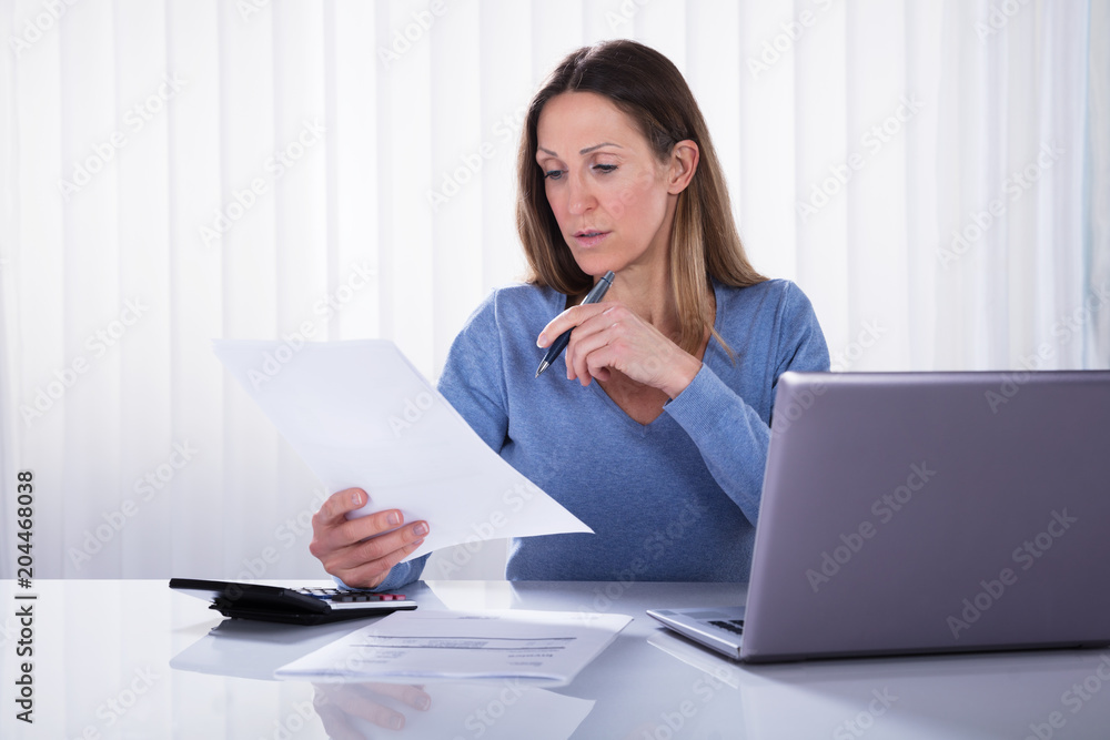 Woman Calculating Invoice With Calculator At Home Woman Calculating Invoice With Calculator At Home