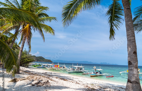 Tropical beach with boats on the Malcapuya Island, Busuanga, Palawan, Philippines. Beautiful tropical island with sand beach. Travel concept