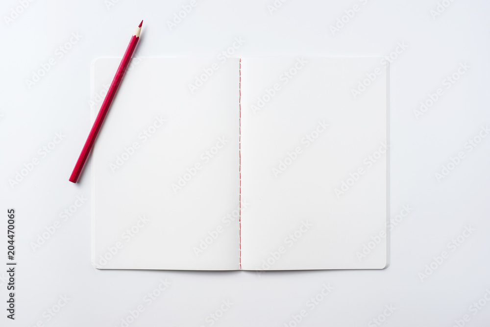 Design concept - Top view of notebook blank page and red pencil isolated on white background for mockup Design concept - Top view of notebook blank page and red pencil isolated on white background for mockup