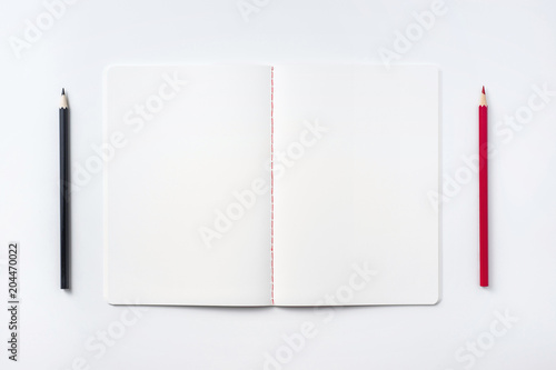 Design concept - Top view of notebook blank page and pencil isolated on white background for mockup © voyata