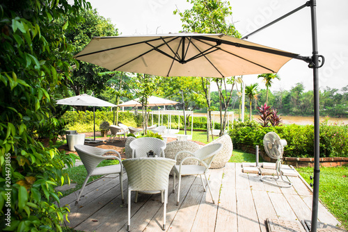 Outdoor furniture, rattan chairs and glass table on the terrace in the garden.