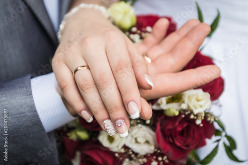 Hands of just married bride and groom with rings. Wedding photograph