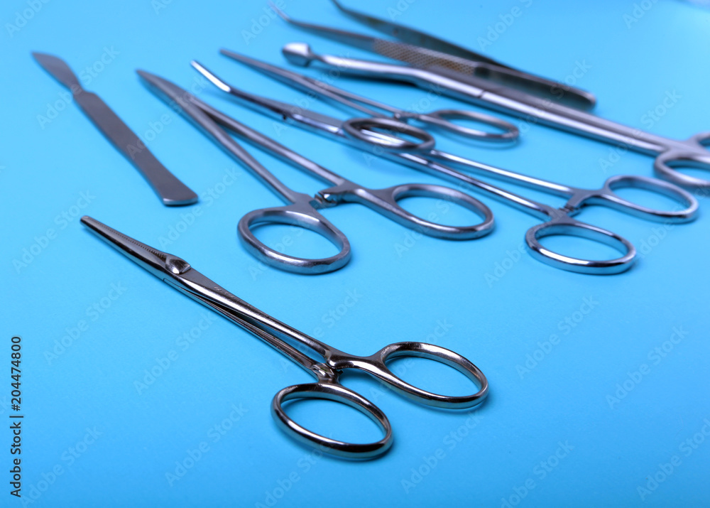 surgical instruments and tools including scalpels, forceps and tweezers arranged on a table for a surgery. surgical instruments and tools including scalpels, forceps and tweezers arranged on a table for a surgery.