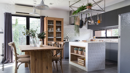 cozy pantry area with natural wood dining table and stainless hanging  shelves in modern vintage style