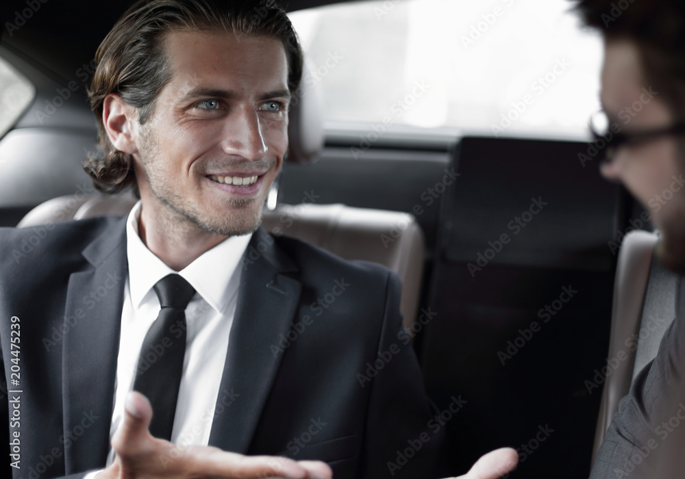 business partners sitting on the backseat of the car business partners sitting on the backseat of the car