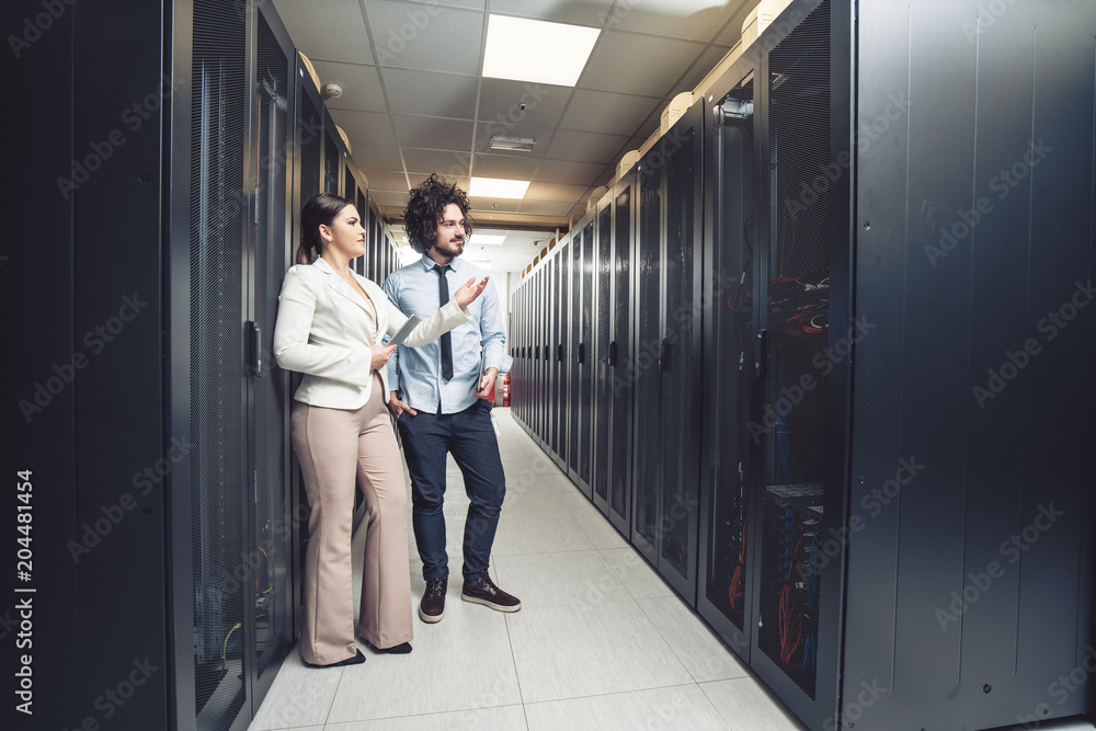 Man and woman working on servers at data center Man and woman working on servers at data center