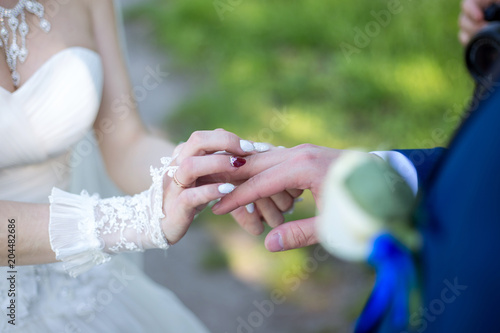 the bride puts on the wedding ring of the groom