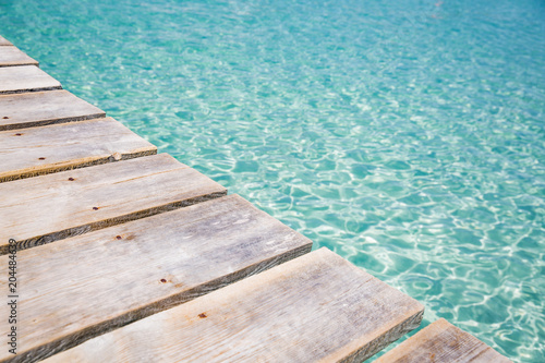 Background of wooden deck and blue water see. Mallorca  Spain. Top view. 