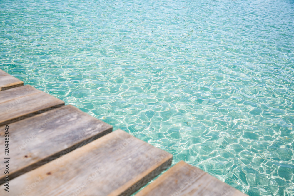 Background of wooden deck and blue water see. Mallorca, Spain. Top view. 