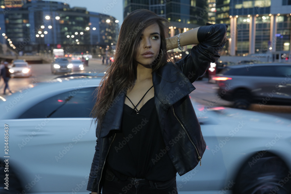 Beautiful woman on a background of a night city and passing cars. Beautiful woman on a background of a night city and passing cars.