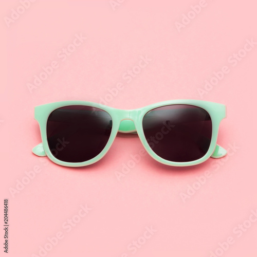 Mint sunglasses isolated on pink background. Closeup. Square image.