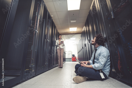 male technician inspecting and working on servers in server room © fotoinfot