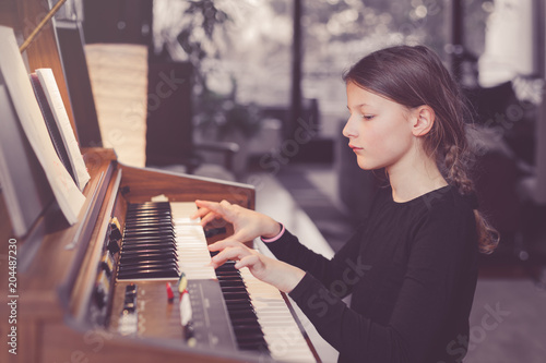 Young girl playing organ at home